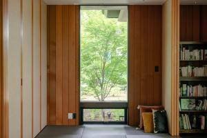 um quarto com uma janela e uma estante de livros em La Maison Karuizawa em Karuizawa