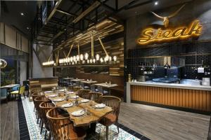 a restaurant with a long wooden table and chairs at Titanic Deluxe Lara in Lara