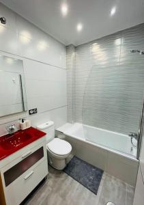 y baño con aseo y lavabo rojo. en A&C Centro-Torre del mar - Málaga, en Torre del Mar