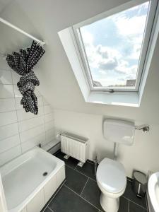 a bathroom with a window and a toilet and a bath tub at Apartments in Trittau near Hamburg in Trittau