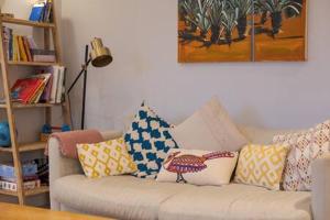 ein Wohnzimmer mit einem Sofa mit Kissen darauf in der Unterkunft Trendy Hampstead Flat RH7 in London