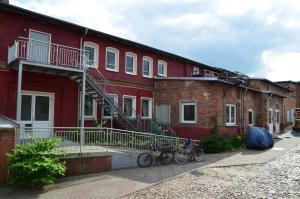 czerwony budynek z rowerami zaparkowanymi przed nim w obiekcie Villa Backstein OBO19 w mieście Schwerin