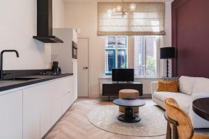 a kitchen and living room with a couch and a table at Shortstay - De Pastorie, Gouda in Gouda