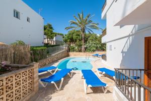 een villa met een zwembad en blauwe stoelen bij Gran Sol Family 4 in Felanitx