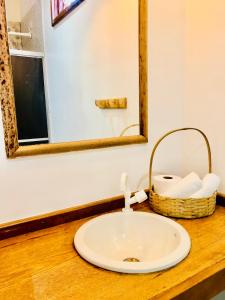 un lavabo con espejo y una cesta de toallas. en Pousada Salinas de Atins en Atins