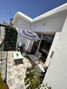 a patio with an umbrella and a table and chairs at Aphrodites Suite in Paphos