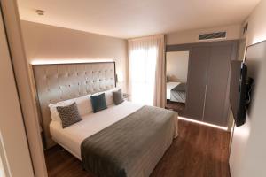 1 dormitorio con 1 cama grande y TV en Gran Hotel Havana 4Sup by Escampa Hotels, en Barcelona