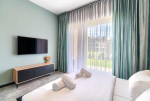 1 dormitorio con cama blanca y ventana grande en Apartamenty Laguna Beskidów - A54, en Zarzecze