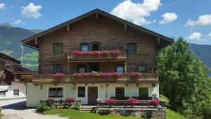 a house with a balcony with pink flowers on it at Hintergugg in Mittersill