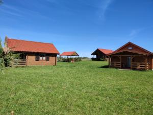 eine Reihe von Cottages auf einem Grasfeld in der Unterkunft Domki na zaciszu w Rynie in Ryn