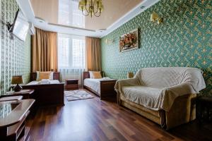 a living room with green wallpaper and a couch and a chair at Poznyakoff Aparthotel in Kyiv