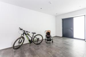 a bike parked in a room with a stroller at Kaiser Apart Walchsee - Familie Hall in Walchsee