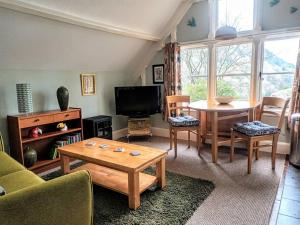 un soggiorno con tavolo e TV di Bird's Eye View apartment at Countisbury Lodge a Lynmouth