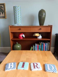 a table with two pillows on it with a book shelf at Bird's Eye View apartment at Countisbury Lodge in Lynmouth