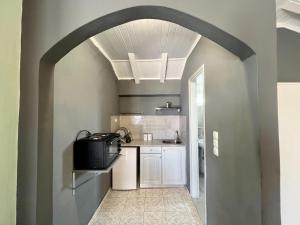 un arco che conduce a una cucina con lavandino di Issos Studios ad Agios Georgios
