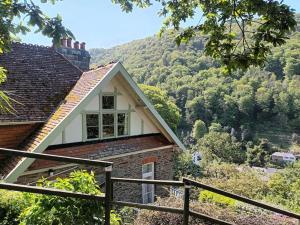 a house with a mountain in the background at Bird's Eye View apartment at Countisbury Lodge in Lynmouth