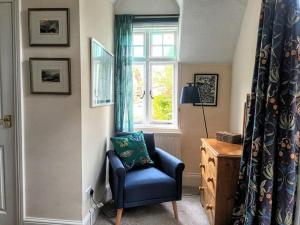 a blue chair in a room with a window at Bird's Eye View apartment at Countisbury Lodge in Lynmouth