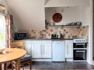 a kitchen with white appliances and a wooden table at Bird's Eye View apartment at Countisbury Lodge in Lynmouth