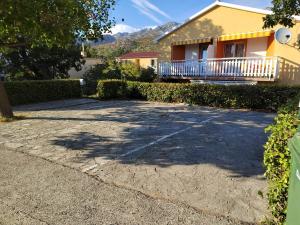 a driveway in front of a yellow house at Apartmani Mala Paklenica in Seline