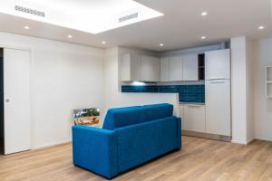 a blue couch in a living room with a kitchen at Villa Mare Pineto in Pineto