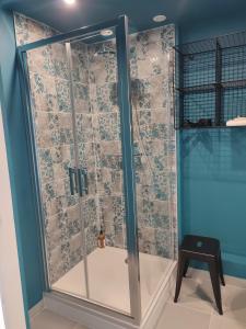 W łazience znajduje się prysznic ze szklanymi drzwiami. w obiekcie Villa Mamba w mieście Saint-Porchaire