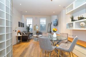 a living room with a glass table and chairs at Award Winning 2 Bedroom House, King's Cross in London