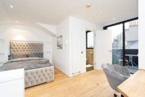 um quarto com uma cama, uma mesa e uma cadeira em Award Winning 2 Bedroom House, King's Cross em Londres