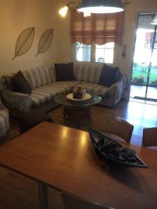 un soggiorno con divano e tavolo di The Little Blooming House a Agíasma