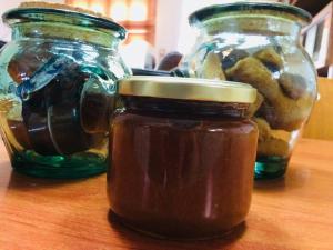 tres jarras de miel de vidrio sobre una mesa de madera en The Little Blooming House, en Agíasma