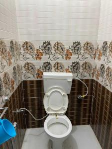 a bathroom with a toilet with a flower pattern on the wall at OYO Flagship Hari Castle in Kānpur