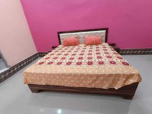 sypialnia z łóżkiem z różową ścianą w obiekcie OYO Flagship Hari Castle w mieście Kanpur