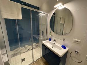 ein Badezimmer mit Dusche, Waschbecken und Spiegel in der Unterkunft Domus Luca - Central Rooms in the Heart of Naples in Neapel