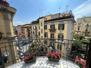 ein Balkon mit zwei Topfpflanzen und Gebäuden in der Unterkunft Domus Luca - Central Rooms in the Heart of Naples in Neapel