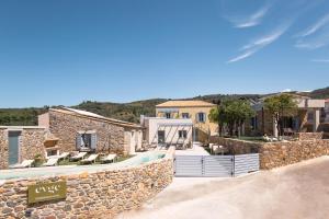 a villa with a swimming pool and a stone wall at Evge Experience Boutique Hotel in Kafoúros