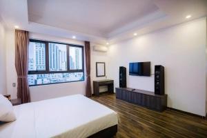 1 dormitorio con 1 cama y TV de pantalla plana en La Casa Hotel Nha Trang, en Nha Trang
