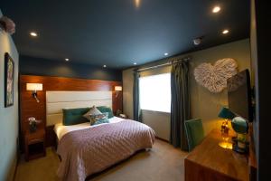 een slaapkamer met een groot bed en een raam bij The Devon Hotel in Exeter