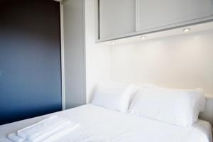 a white bed with white pillows and a cabinet at Sea view Monaco Monte Carlo in Beausoleil