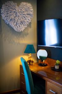 a desk with a monitor and a chair and a lamp at The Devon Hotel in Exeter
