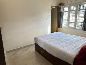 a bedroom with a bed in a room with a window at Anthara service apartments in Belūr