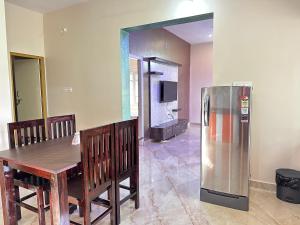 a dining room with a table and a refrigerator at Anthara service apartments in Belūr