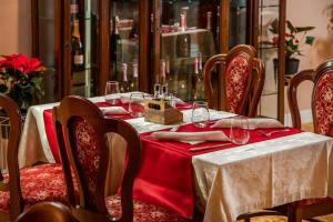 a table with a red table cloth and wine glasses on it at Hotel Cvita in Split