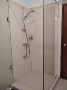La salle de bains est pourvue d'une douche avec une porte en verre. dans l'établissement A tropical paradise; stunning house, pool, garden, à Wattala
