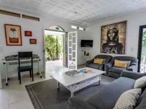 uma sala de estar com um sofá e uma mesa em Gaïa's Garden B&B Abidjan em Abidjan