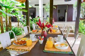 a table with breakfast foods and orange juice on it at Ga&iuml;a's Garden B&B Abidjan in Abidjan