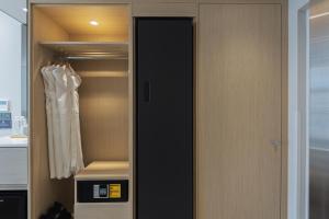 a closet with a black door and a white robe at Hotel Marine view in Busan