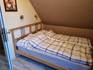a bed with a plaid blanket on it in a room at DOMEK NA BASZCIE klimatyzowany in Lesko
