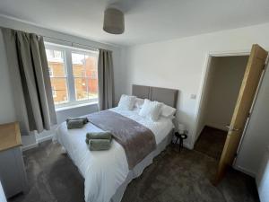 una camera da letto con un grande letto bianco con cuscini di Cosy apartment in Eccleshall a Eccleshall