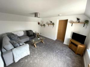 a living room with a couch and a television at Cosy apartment in Eccleshall in Eccleshall