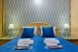 Un dormitorio con una cama azul con toallas. en Poznyakoff Aparthotel, en Kiev