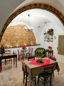 uma sala de estar com mesas e cadeiras e uma parede de pedra em Le Stanze dell'Emiro em Sambuca di Sicilia